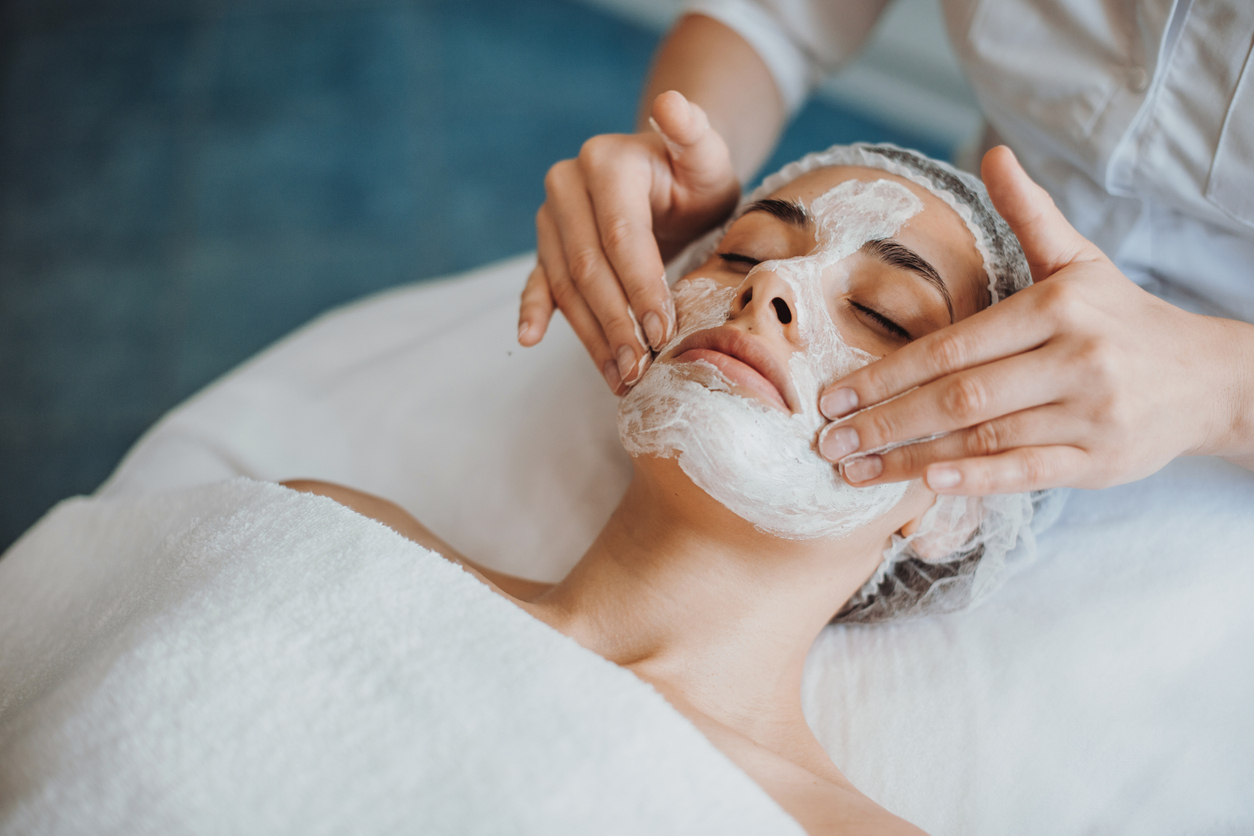Woman getting a face mask treatment at a spa.