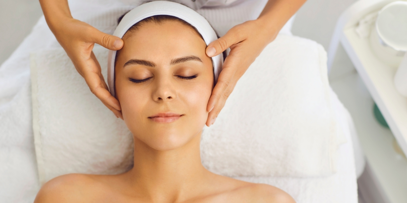 Woman getting a facial massage from a spa specialist.